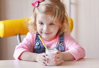 Cute little girl with yogurt at home