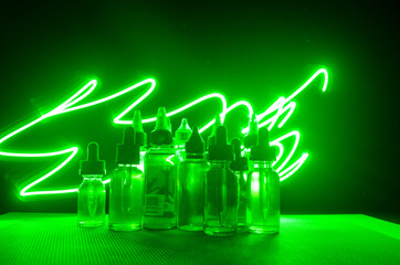 Vape concept. Smoke clouds and vape liquid bottles on dark background. Light effects.