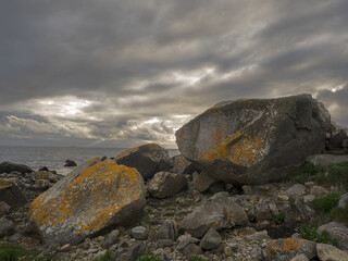 Huge rocks on West Coast of Ireland and the Ocean in the background at dusk and under dramatic sky.