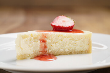 cheesecake with strawberry on plate closeup, shallow focus