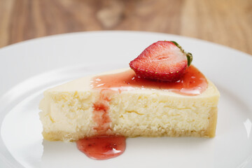 cheesecake with strawberry on plate closeup, shallow focus