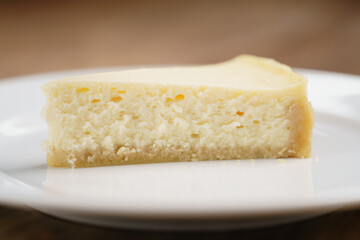 cheesecake on plate on wood table, shallow focus