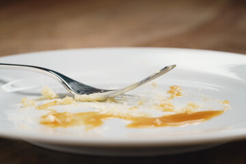 empty plate after eating cheesecake with caramel, shallow focus