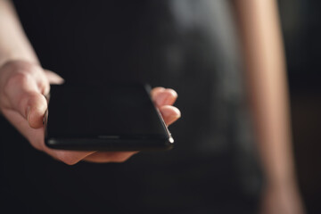 female teen hand holding smartphone closeup shot, shallow focus