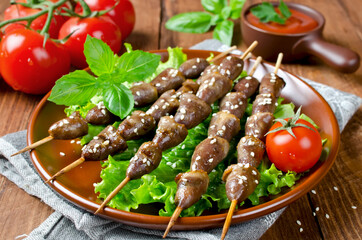 Chicken hearts on a barbecue sticks topped with sesame seeds
