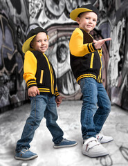 Two brothers  in the style of hip hop.Fashionable team.Graffiti on the walls.