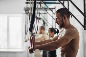 Fitness dip ring man relaxed after workout at gym dipping exercise