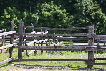Fototapeta na wymiar Old wooden rural corral fense in meadow