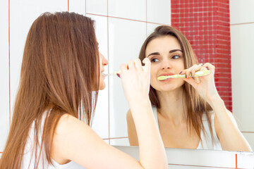 a young woman brushing teeth