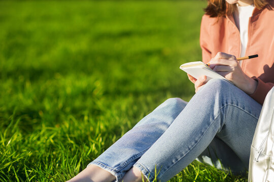 Tourist girl making notes or sketches