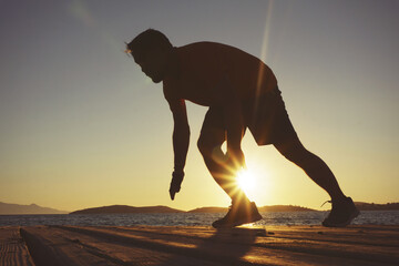 Fototapeta na wymiar Silhouettes of runner man at beach