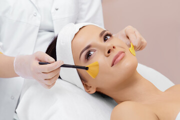 Obraz na płótnie Canvas Cosmetology. Spa clinic. Beautiful woman at facial treatment procedure. Young healthy skin. Facial mask. Skin rejuvenation.