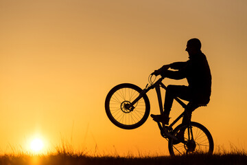 Fototapeta na wymiar Silhouette of cycling on sunset background