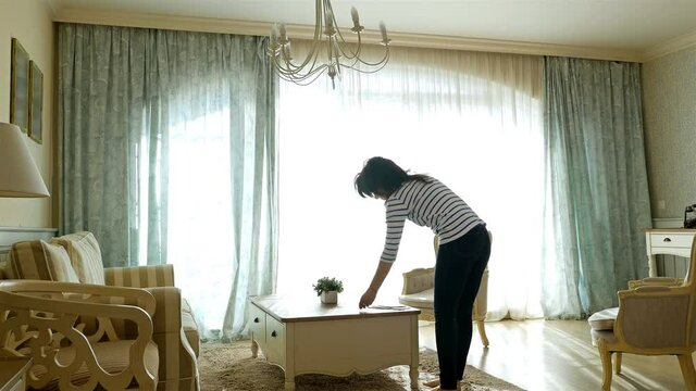 Woman returning home reviewing household bills and packages on the table