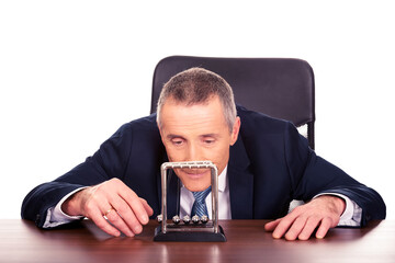 Businessman in office playing with newton balls