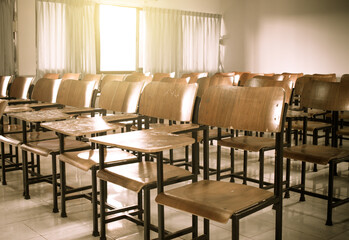 School classroom with old, dirty lecture wooden desk and chair in high school thailand, vintage tone education concept