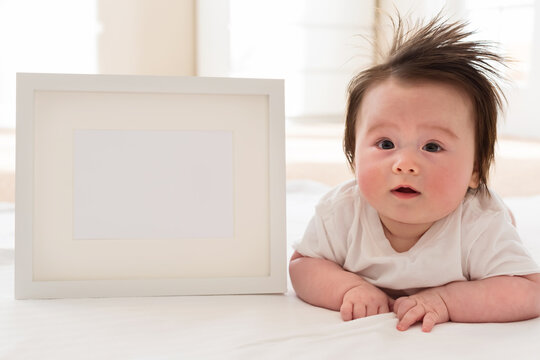 Happy baby boy with white photo frame