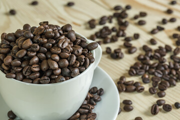 close up coffee beans in cup with  wooden background, selective focus and effect filter.
