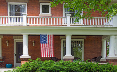 old brick house with American flag hanging on front porch