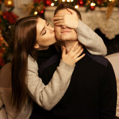 Cute lovers staying at home and enjoying tome together. Joyful girl close her husband or boyfriend...