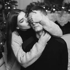 Cute lovers staying at home and enjoying tome together. Joyful girl close her husband or boyfriend...