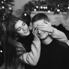 Cute lovers staying at home and enjoying tome together. Joyful girl close her husband or boyfriend...