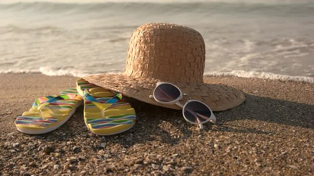 Flip flops and wicker hat. Sunglasses on the seashore. Vacation by the sea.