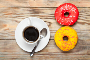 Cup with coffee and donuts on a wooden background