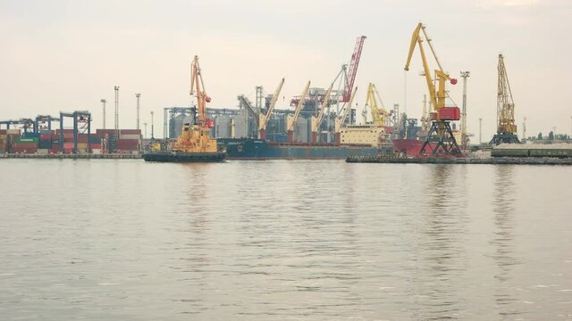 Tugboat and port. Cranes at the harbor. Ship maintenance and repair.