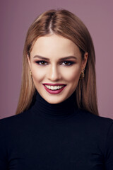 The face of beauty. Woman with long straight blonde hair, cherry lips and colorful eye shadow. Happy joyous smiling woman