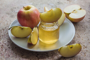 Organic honey in glass jar and red apple on the plate