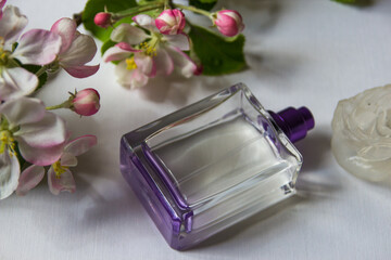 Women's perfume and spring apple blossom branch. Female romantic perfumes