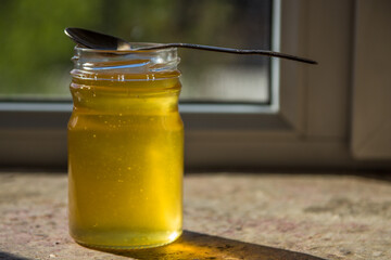 Organic pure honey in jar on window sill