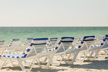 Lots of sun loungers on the beach near the sea.