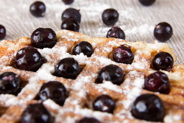 Belgian waffles with berries sprinkled with powdered sugar