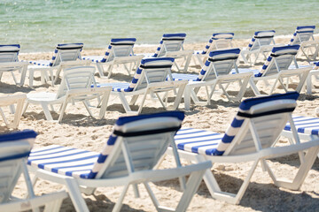 Lots of sun loungers on the beach near the sea.