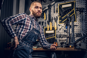 Obraz na płótnie Canvas Bicycle mechanic in a workshop with bike parts on background.