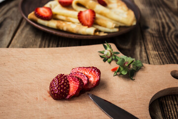 strawberry and knife with crepes on background