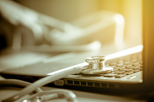 Medicine doctor's working on laptop computer and hand doctor on background. Focus on stethoscope