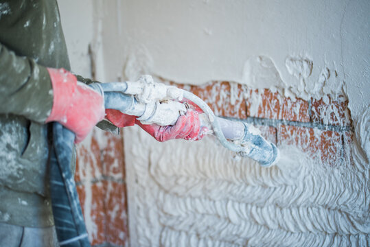 spraying plaster on wall