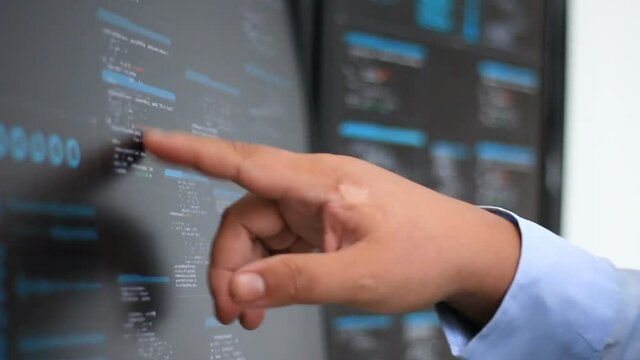 Close up shot hand of man using touch screen monitor with random coding