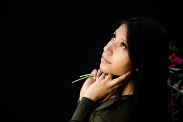 Pensive Hispanic woman. black background