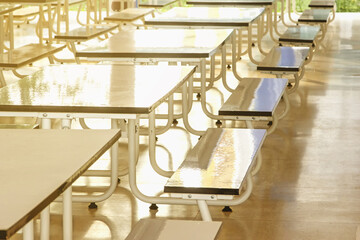 Rows of tables in the cafeteria for students.