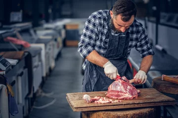 Fotobehang Bearded butcher cut fresh bacon meat. © Fxquadro