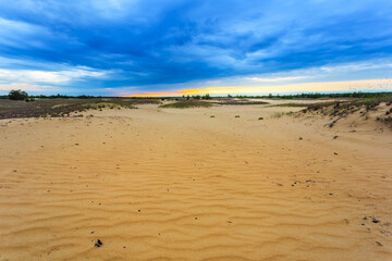 sandy desert under a dramatic sky