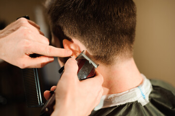 Master cuts hair and beard of men in the barbershop