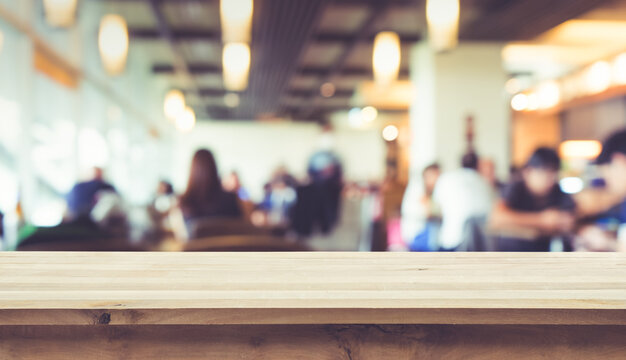 Wood table top with blur of people in coffee shop or (cafe,restaurant )background.For montage product display or key visual layout