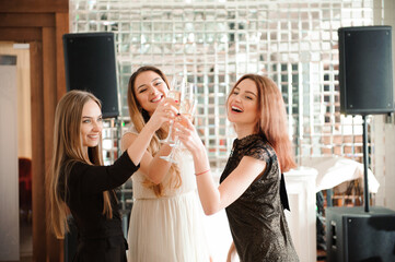 Portrait of smiling friends holding glass of champagne while dancing at bar