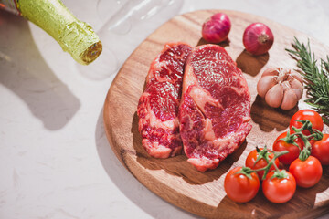 Raw beef on a cutting board  with spices and ingredients for cooking.