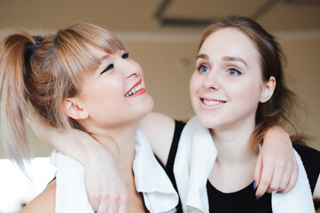  two sportive pretty women having rest after successful jogging workout in the gym. Cute female take a rest after hard physical activity Sporty friends portrait